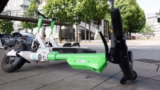 Ein E-Scooter liegt umgekippt auf einem Gehweg.