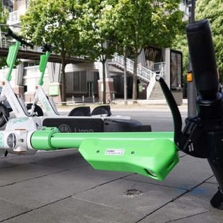 Ein E-Scooter liegt umgekippt auf einem Gehweg.