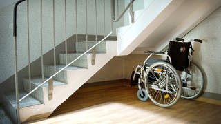 Symbolbild: Ein Rollstuhl steht neben einer Treppe