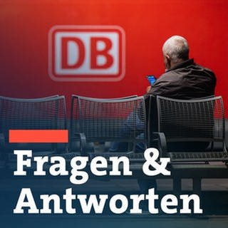 Das Logo der Deutschen Bahn (DB) prangt an der Seite einer Lok, während ein Mann auf dem Hauptbahnhof wartet. 