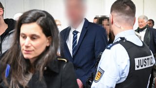 Der inzwischen suspendierte Inspekteur der Polizei Baden-Württemberg, kommt zum Prozessauftakt mit seiner Anwältin in das Gerichtsgebäude. 