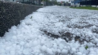 Hagelkörner liegen nach einem Unwetter am Straßenrand. Der Deutsche Wetterdienst (DWD) warnte vor Unwettern in Teilen Baden-Württembergs.