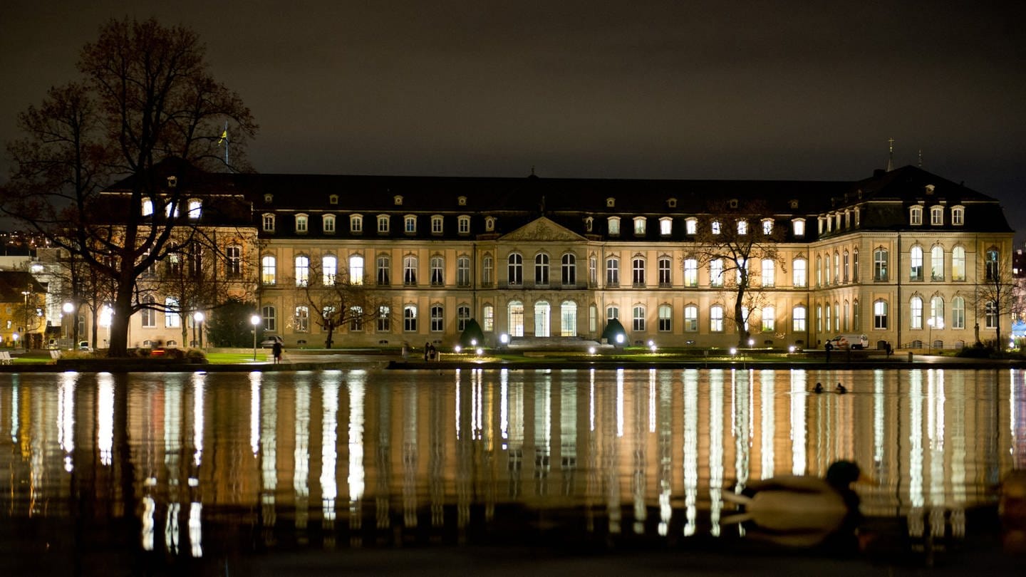 Das Neue Schloss spiegelt sich abends in einem Teich im Schlossgarten.