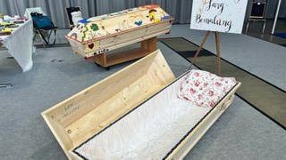 Auf der Messe "Leben und Tod" in Freiburg steht ein bunt bemalter Sarg.