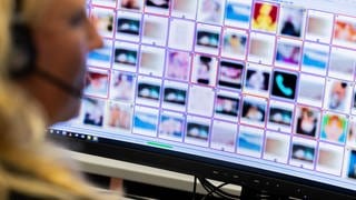 Eine Ermittlerin sitzt vor Monitoren mit unkenntlich gemachten Fotografien, die teilweise sexuellen Missbrauch zeigen.