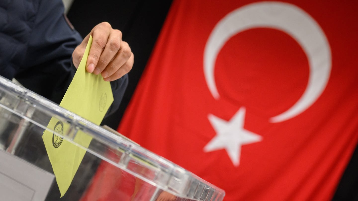 Ein Wähler wirft seinen Stimmzettel für die türkische Präsidentschaftswahl in eine Urne.