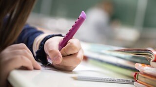 Eine Schülerin sitzt im Klassenzimmer.