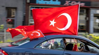 Anhänger des türkischen Präsidenten Erdogan fahren in einem Autokorso mit türkischen Fahnen, noch vor dem amtlichen Ergebnis der Stichwahl in der Türkei, jubelnd durch den Duisburger Norden.
