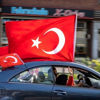 Anhänger des türkischen Präsidenten Erdogan fahren in einem Autokorso mit türkischen Fahnen, noch vor dem amtlichen Ergebnis der Stichwahl in der Türkei, jubelnd durch den Duisburger Norden.