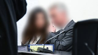 Der suspendierte Inspekteur der Polizei (rechts) sitzt als Angeklagter im Prozess wegen sexueller Nötigung neben seiner Frau im Gerichtssaal. 