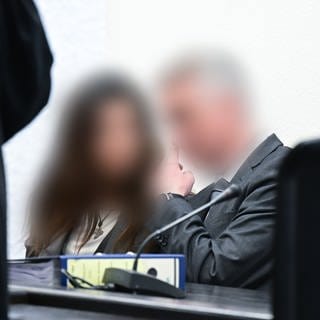 Der suspendierte Inspekteur der Polizei (rechts) sitzt als Angeklagter im Prozess wegen sexueller Nötigung neben seiner Frau im Gerichtssaal. 