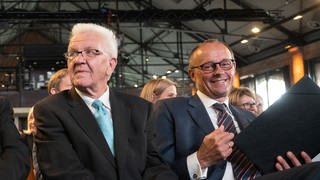Winfried Kretschmann (Bündnis 90Die Grünen), Ministerpräsident von Baden-Württemberg und Friedrich Merz, Bundesvorsitzender der CDU, sitzen vor Beginn eines Festakts anlässlich des 80. Geburtstags des ehemaligen Bundestagspräsidenten Schäuble in der 1. Reihe.