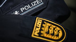 Eine Uniform der Polizei Baden-Württemberg liegt auf einem Sessel. 