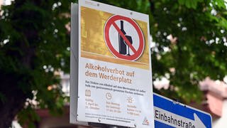Am Karlsruher Werderplatz ist ein Schild angebracht, das auf ein Alkoholverbot außerhalb von gastronomisch genutzten Flächen von Montag bis Samstag in der Zeit von 11.00 Uhr bis 20.00 Uhr auf dem Platz hin weist.