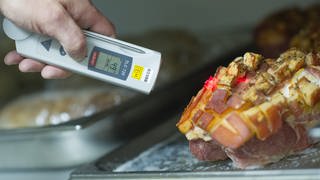 Ein Lebensmittelkontrolleur der Stadt Mannheim überprüft am bei einer Betriebskontrolle die Temperatur einer Fleischware.