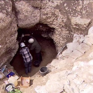 Wissenschaftler führen in einer eiszeitlichen Höhle Untersuchungen durch