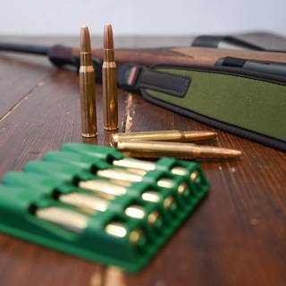 Ein Jagdgewehr und Munition vom Kaliber 30-06 Springfield liegen auf einem Tisch. 