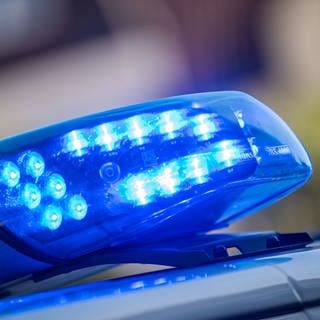 Ein Blaulicht ist auf dem Dach eines Polizeifahrzeugs zu sehen. 