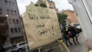 Hinweisschild auf Schaufenster: Wir schließen unser Geschäft