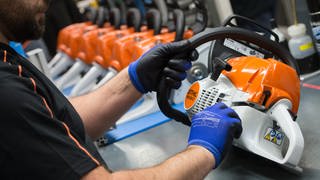 Ein Mitarbeiter des Motorsägenherstellers Stihl montiert in einem Werk in Waiblingen (Baden-Württemberg) eine Motorsäge.