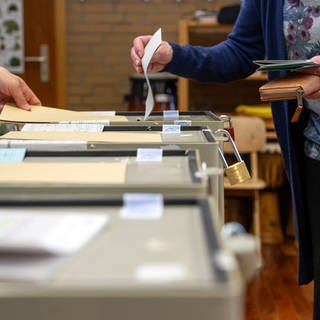 Ein Frau wirft in Bayern bei der Landtagswahl ihren Stimmzettel in die Wahlurne. 