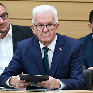 Winfried Kretschmann (Grüne), Ministerpräsident von Baden-Württemberg, sitzt im Landtag von Baden-Württemberg im Rahmen einer Debatte über Antisemitismus auf der Regierungsbank.