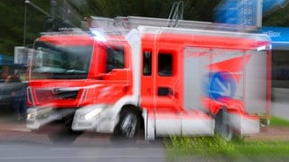 Feuerwehreinsatz im Kölner Stadtteil Höhenberg - Ein Löschfahrzeug der feuerwehr fährt mit Blaulicht durch eine Straße zu einem Einsatz 