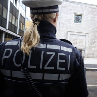 Eine Polizistin steht vor dem Gemeindezentrum sowie der Synagoge der Israelitischen Religionsgemeinschaft Württembergs in Stuttgart.