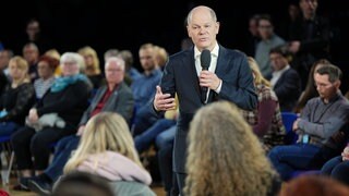 Bundeskanzler Olaf Scholz (SPD) beantwortet in der Cottbuser Stadthalle im Rahmen der Reihe "Kanzlergespräche" Fragen aus dem Publikum.