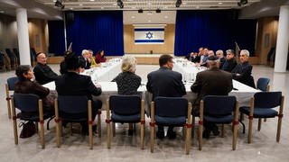Vertreter der israelitischen Religionsgemeinschaften und von muslimischen Verbänden unterhalten sich in der Synagoge während eines Treffens.