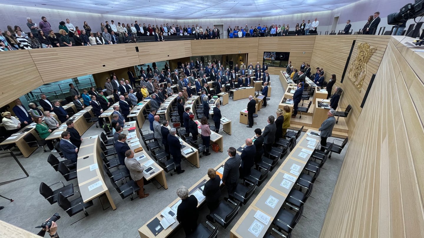 Abgeordnete und Besucher des Landtags von Baden-Württemberg stehen bei einer Schweigeminute für alle Opfer antisemitischer Verbrechen anlässlich einer Debatte zum Kampf gegen Antisemitismus im Plenarsaal in Stuttgart.