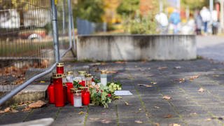 Blumen und Kerzen liegen vor der Schule in Offenburg, an der ein Schüler erschossen wurde. 