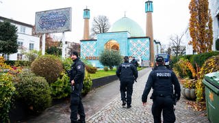 Einsatzkräfte der Polizei stehen während einer Razzia beim islamischen Zentrum Hamburg vor der Imam Ali Moschee (Blaue Moschee) an der Außenalster. 