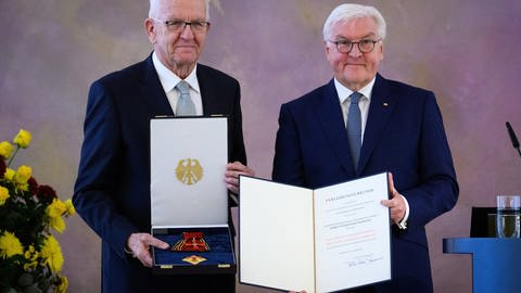 Bundespräsident Frank-Walter Steinmeier (rechts) verleiht Winfried Kretschmann, Ministerpräsident von Baden-Württemberg, im Schloss Bellevue das Bundesverdienstkreuz.