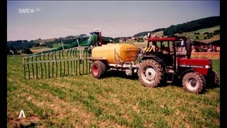 ein Traktor verteilt Gülle auf einem Feld