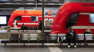 Reisende warten im Berliner Hauptbahnhof auf ihre Züge. 
