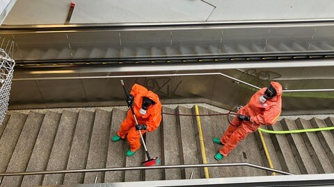 Feuerwehrleute in Spezialanzügen reinigen am Donnerstag (25.1.) in einer Passage im Bereich des Hauptbahnhofs in Stuttgart eine Treppe. Dort war nach Angaben der Bundespolizei ein Graffiti aus gefährlicher Flusssäure entdeckt worden. Weil Flusssäure schwere Verätzungen auf der Haut hervorrufen könne, seien Einsatzkräfte im größeren Stil ausgerückt. Bei der Flusssäure, die auch Fluorwasserstoffsäure genannt wird, handelt es sich um eine farblose, stark stechend riechende Flüssigkeit. Sie kann sich auf Oberflächen einätzen.