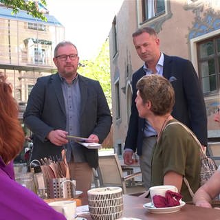 FDP Kandidat Andreas Glück redet mit mehreren Personen