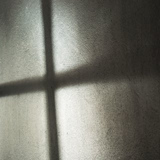 Ein Fenster wirft seinen Schatten auf die Wand.