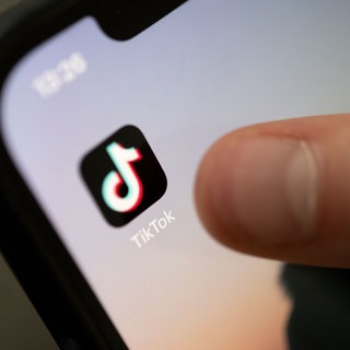 Ein Teenager tippt auf die TikTok-App auf einem Smartphone.