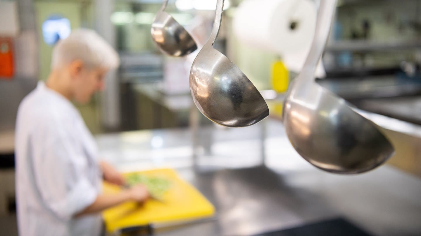 Eine Auszubildende zur Köchin im dritten Lehrjahr arbeitet in einem Hotel in der Küche eines Restaurants.