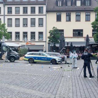 Mitarbeiter der Spurensicherung und Polizei sind nach einer Messerattacke auf dem Mannheimer Marktplatz im Einsatz.