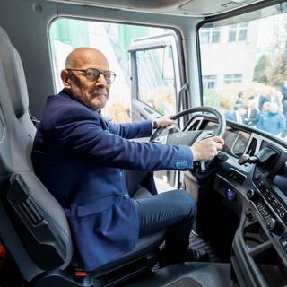 Winfried Hermann (Grüne), Verkehrsminister von Baden-Württemberg, sitzt am Lenkrad im Führerhaus eines neuen Lkw mit Wasserstoff-Antrieb. 