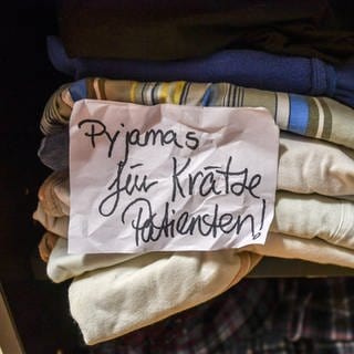 In der Kleiderkammer einer Stadtmission liegen Pyjamas, die für Krätze-Patienten reserviert sind.