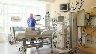 Mannheim: Eine Intensivpflegerin steht an einem Bett mit Beatmungsgerät in einem Patientenzimmer auf der Intensivstation des Universitätsklinikums.