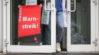 Ein Plakat mit der Aufschrift "Heute Warnstreik" hängt am Eingang eines Gebäudes des Universitätsklinikum Tübingen (Archivbild). 