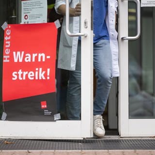 Ein Plakat mit der Aufschrift "Heute Warnstreik" hängt am Eingang eines Gebäudes des Universitätsklinikum Tübingen (Archivbild). 