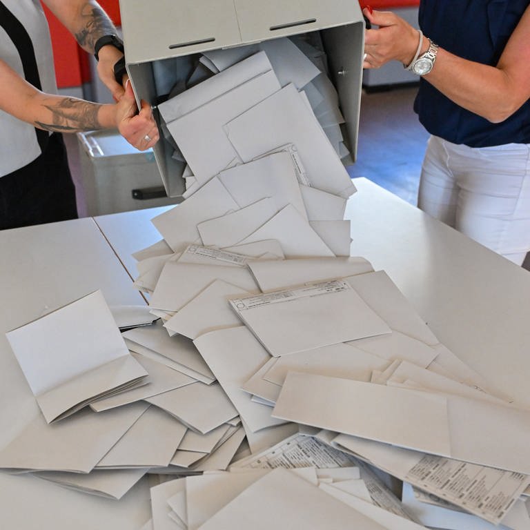 Die Stimmzettel zur Europawahl werden aus einer Wahlurne ausgeschüttet. 