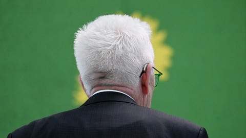 Der baden-württembergische Ministerpräsident Winfried Kretschmann vor einem Banner seiner Partei Bündnis 90Die Grünen.