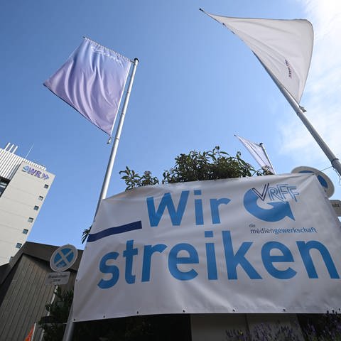 Ein Transparent mit der Aufschrift "Wir streiken" ist vor dem Funkhaus des SWR in Stuttgart zu sehen.